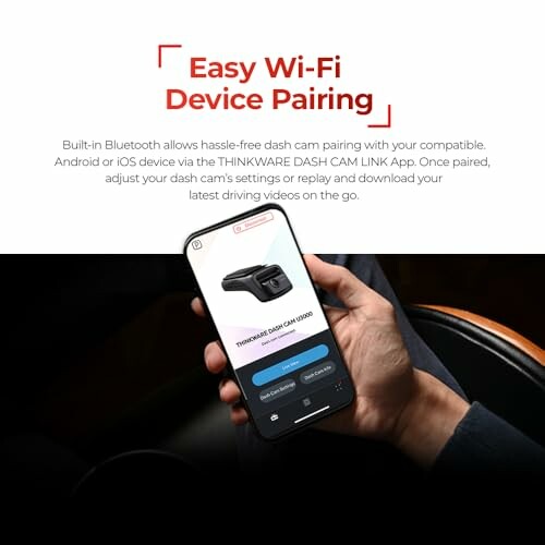 Hand holding phone with dash cam pairing app interface.